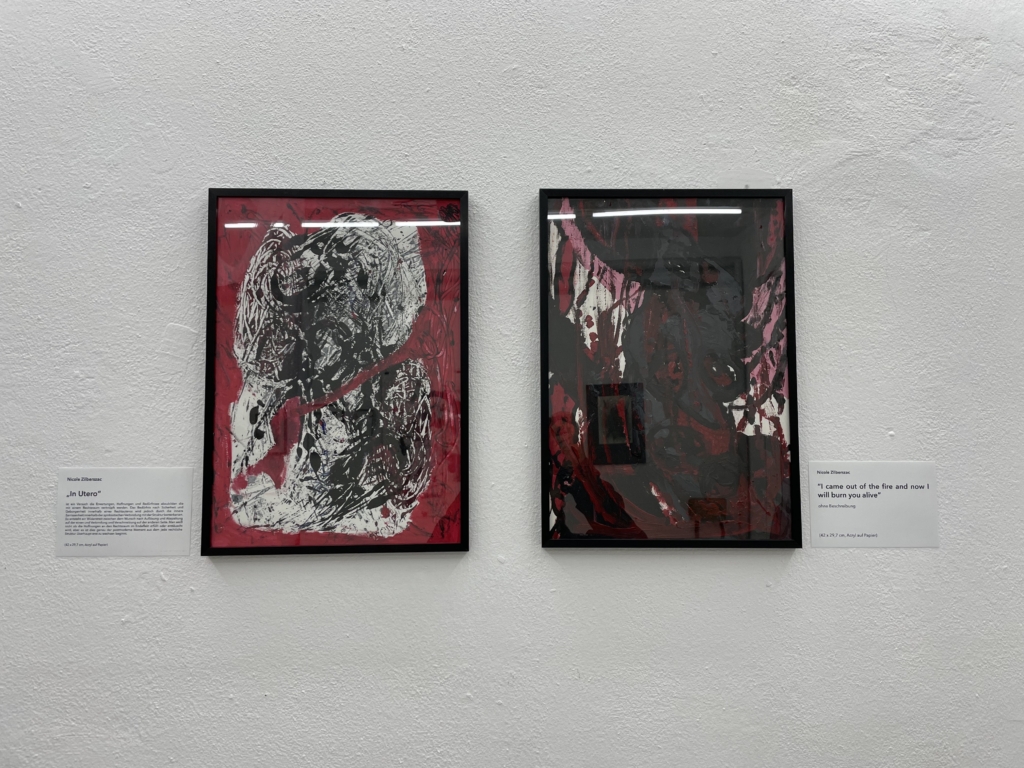 Zwei gerahmte kleinere Gemälde in schwarz und rosa Tönen. Links der Titel "In Utero", rechts der Titel "I came out of the fire and now I will burn alive".